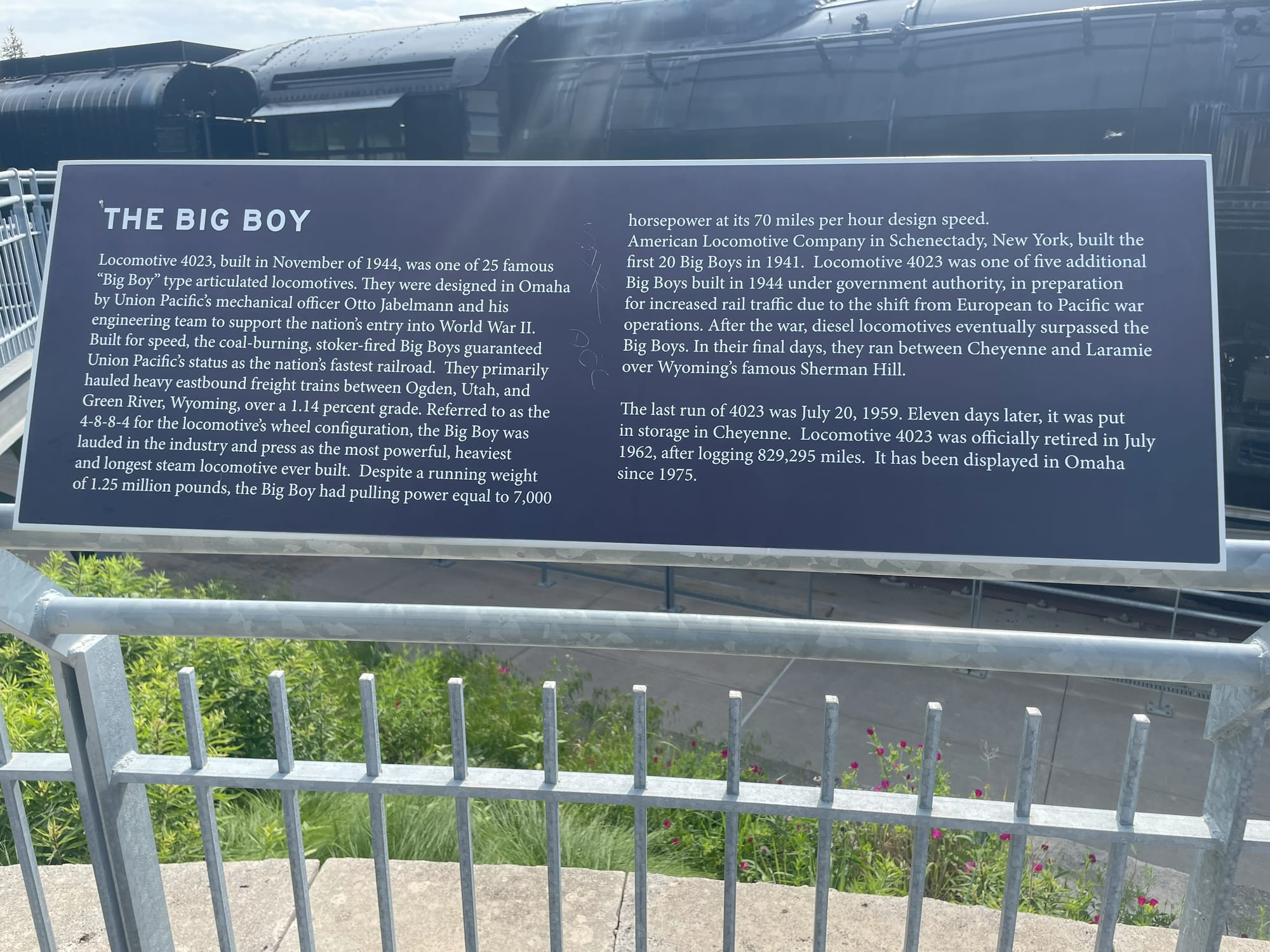 THE BIG BOY  Locomotive 4023, built in November of 1944, was one of 25 famous  "Big Boy" type articulated locomotives. They were designed in Omaha by Union Pacific's mechanical officer Otto Jabelmann and his engineering team to support the nation's entry into World War II.  Built for speed, the coal-burning, stoker-fired Big Boys guaranteed Union Pacific's status as the nation's fastest railroad. They primarily hauled heavy eastbound freight trains between Ogden, Utah, and Green River, Wyoming, over a 1.14 percent grade. Referred to as the 4-8-8-4 for the locomotives wheel configuration, the Big Boy was lauded in the industry and press as the most powerful, heaviest and longest steam locomotive ever built. Despite a running weight of 1.25 million pounds, the Big Boy had pulling power equal to 7,000 horsepower at its 70 miles per hour design speed.  American Locomotive Company in Schenectady, New York, built the first 20 Big Boys in 1941. Locomotive 4023 was one of five additional Big Boys built in 1944 under government authority, in preparation for increased rail traffic due to the shift from European to Pacific war operations. After the war, diesel locomotives eventually surpassed the Big Boys. In their final days, they ran between Cheyenne and Laramie over Wyoming's famous Sherman Hill.  The last run of 4023 was July 20, 1959. Eleven days later, it was put in storage in Cheyenne. Locomotive 4023 was officially retired in July 1962, after logging 829,295 miles. It has been displayed in Omaha since 1975.