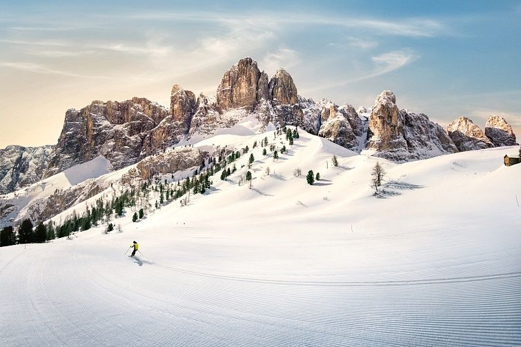 Sella Ronda ski resort first tracks being skied by a single skier in a yellow ski-suit