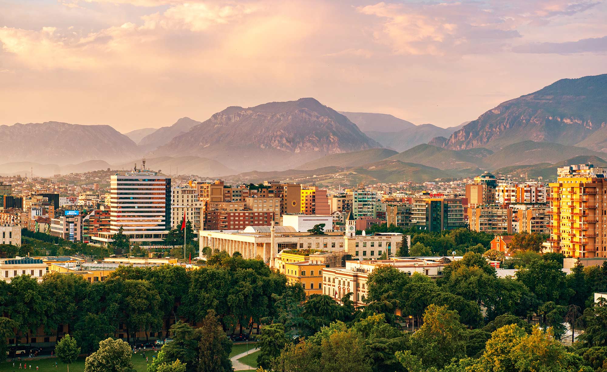 Skyline view of the city of Tirana in Albania, with mountains in the background.
