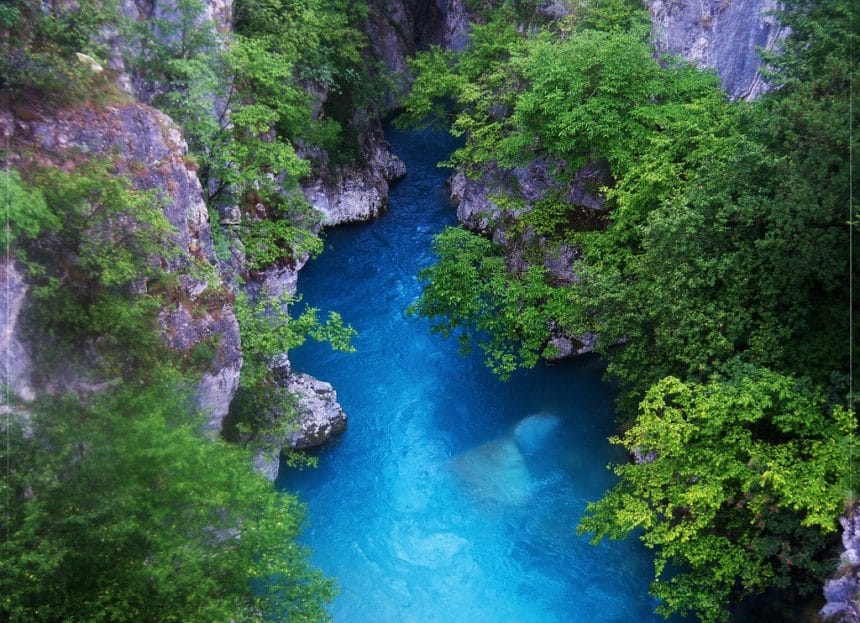 the beautiful blue waters of the Valbona River surrounded by mountains in Albania