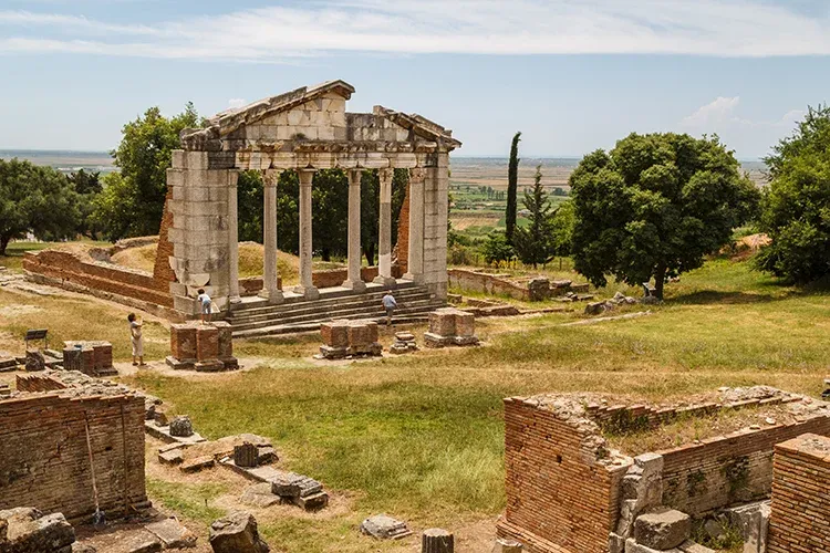 Apollonia UNESCO Site of ancient ruins of columns on a sunny day with partly cloudy skies. 