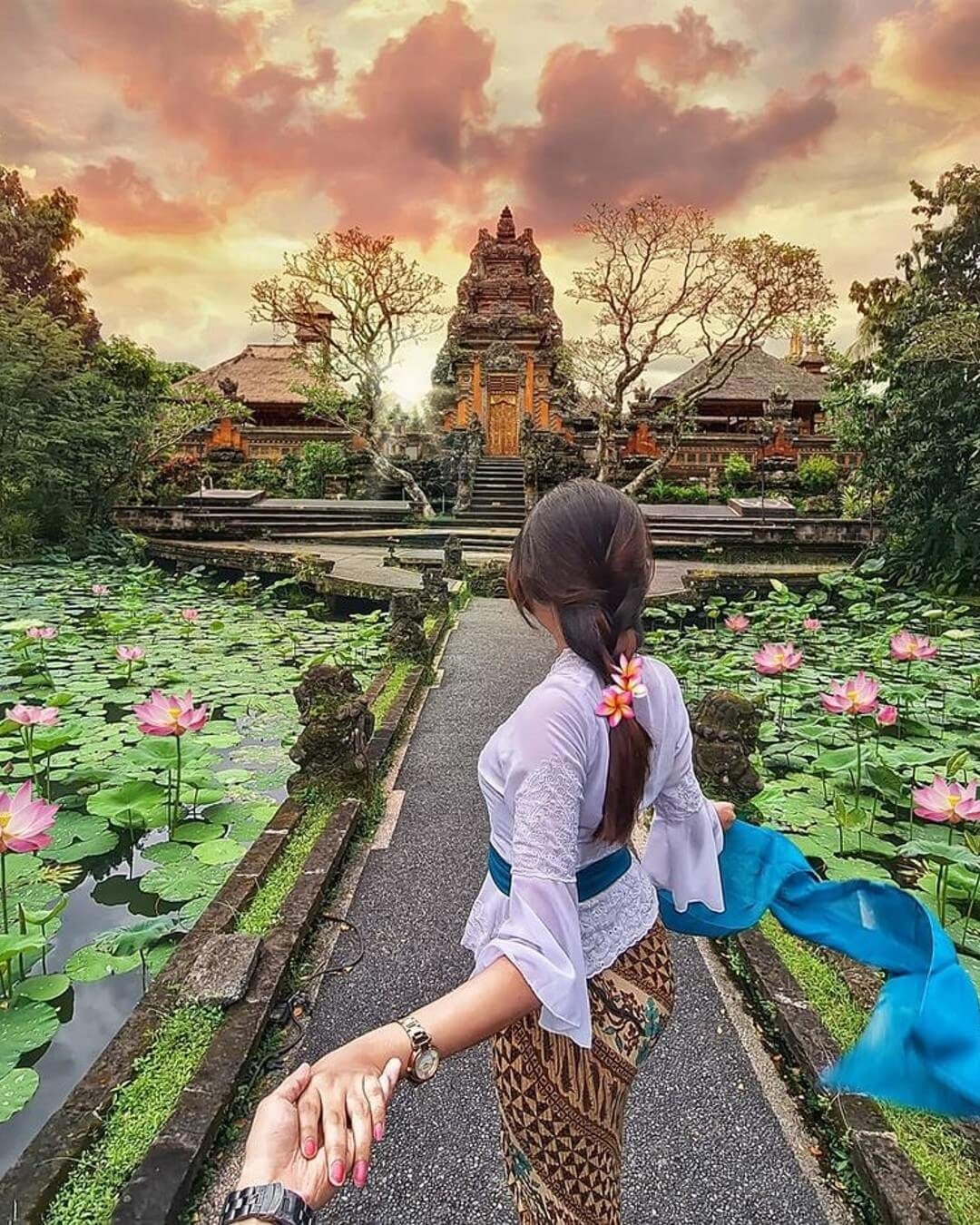 Woman holding hands with partner at Saraswati Temple Ubud Bali
