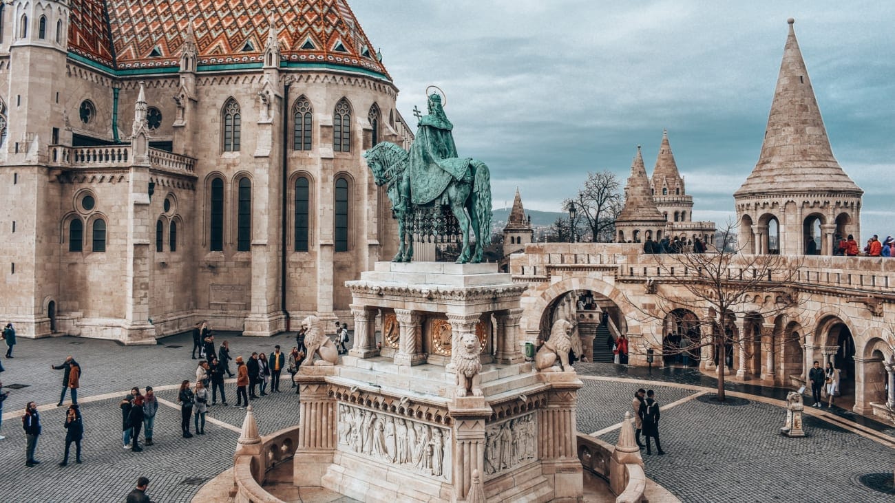 People walking around and exploring Buda Castle in Hungary in a cloudy day.
