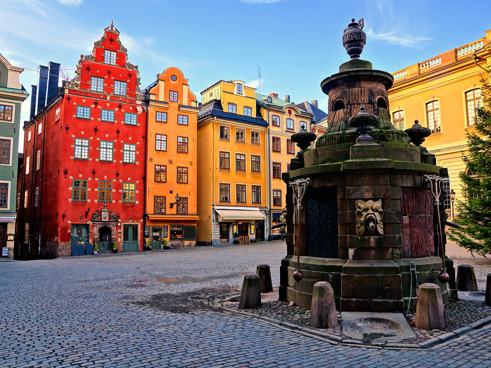 Colorful buildings and an old monument in Gamla Stan, Stockholm, Sweden.