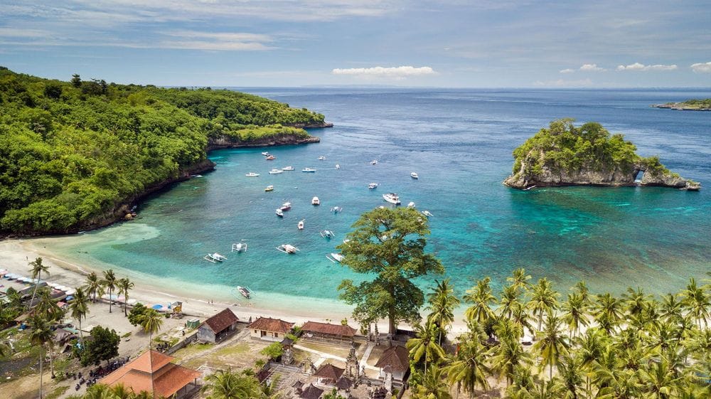 Ariel view of Crystal bay beach in Bali, with boats anchored in the bay. 