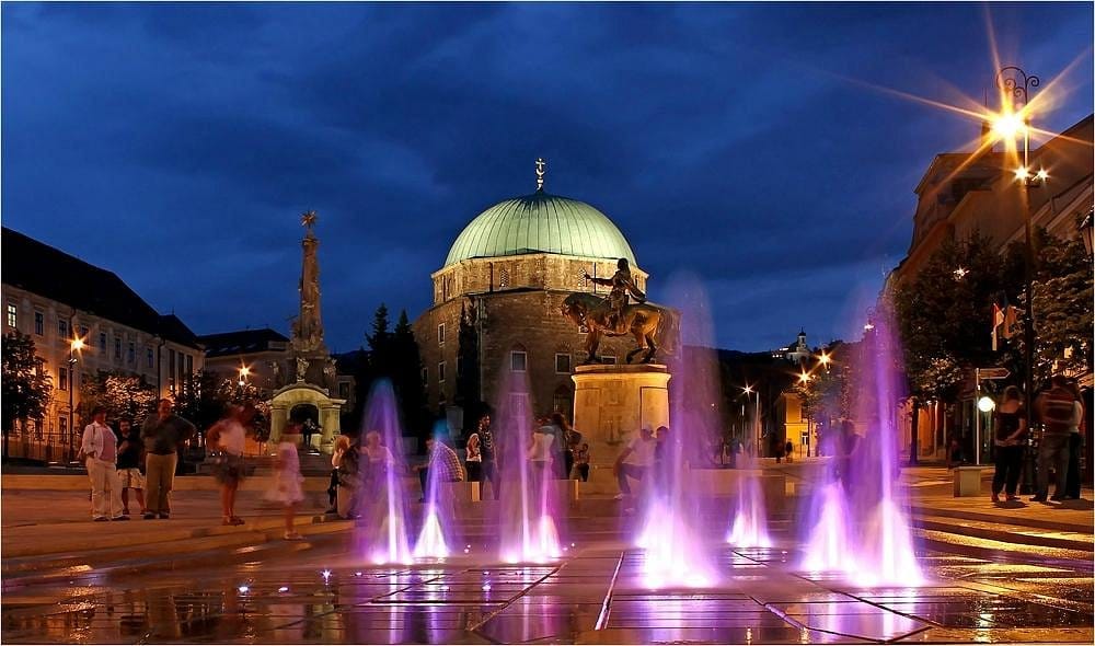 Water fountian that is lit up at night in Pécs, Hungary.