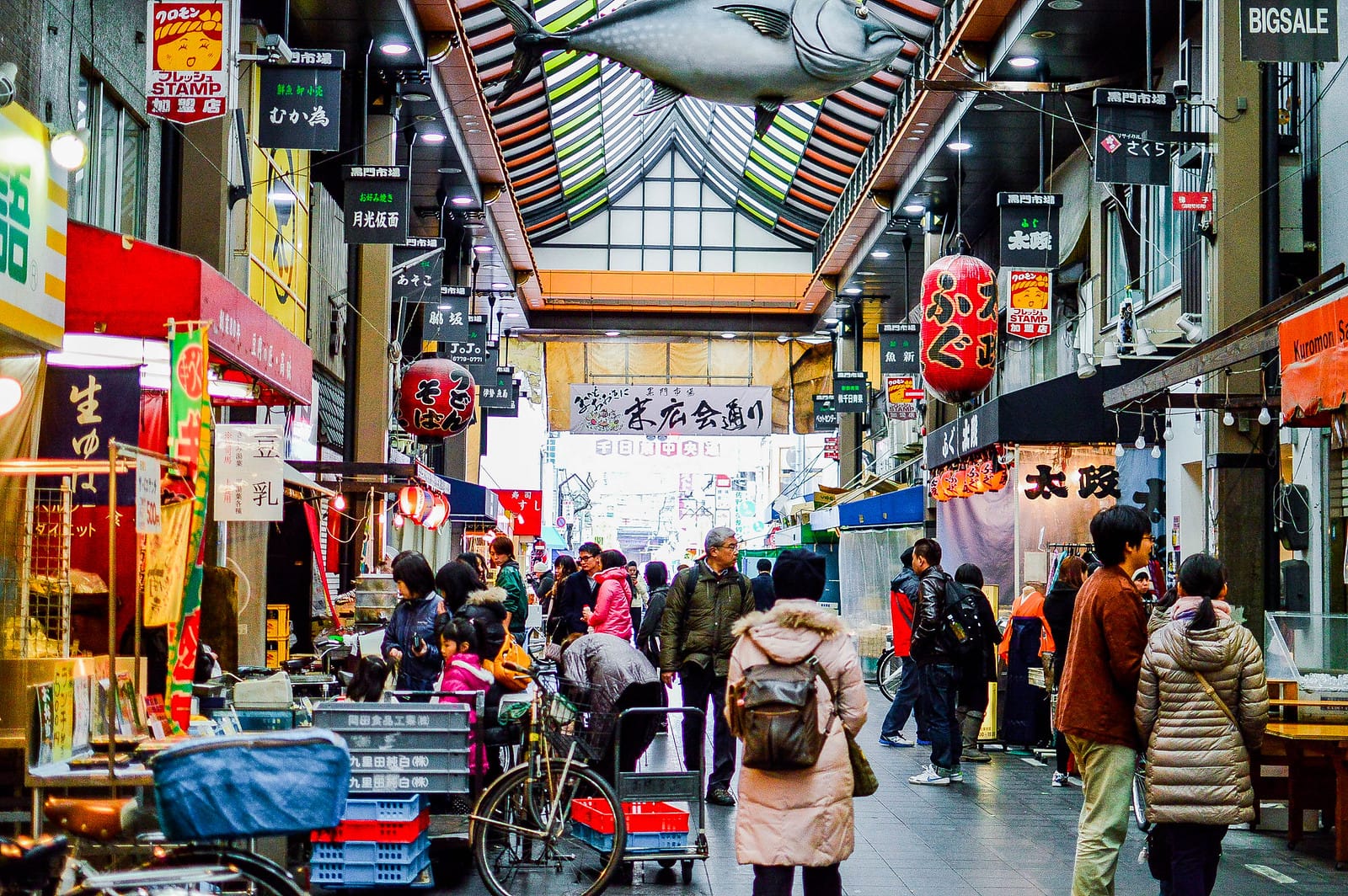 People exploring the Market of Kuromon Ichiba in Osaka.