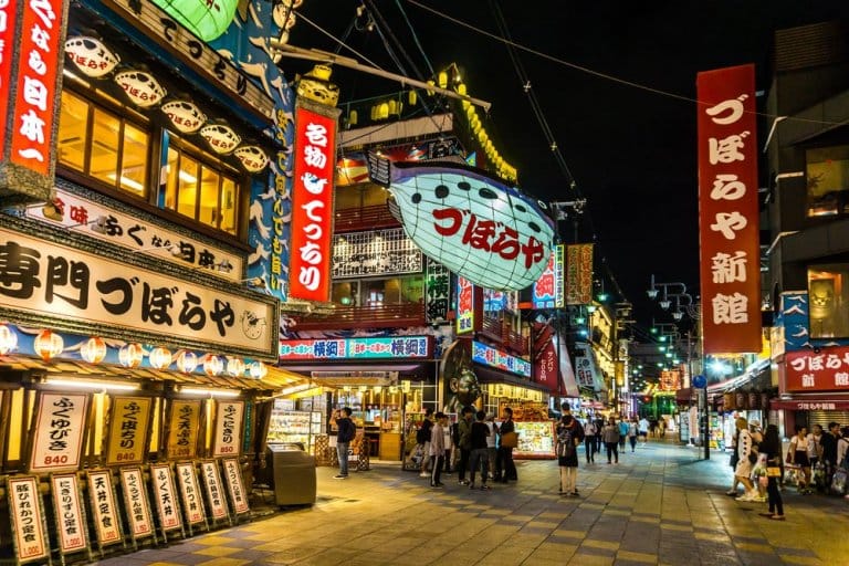 People walking around and exploring the neon lights of Dotonbori in Osaka.
