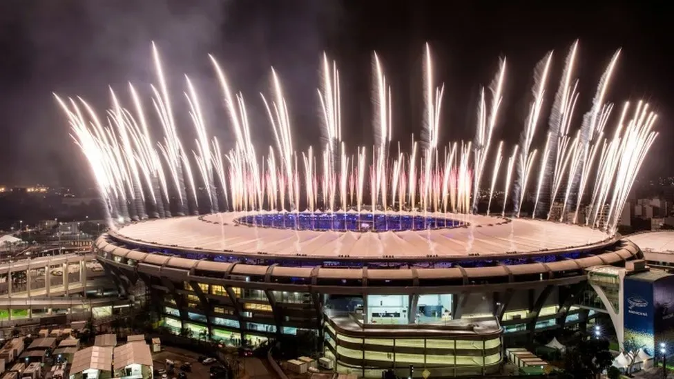Maracanã Stadium In Rio de Janeiro with fireworks shooting off from the stadium at night.