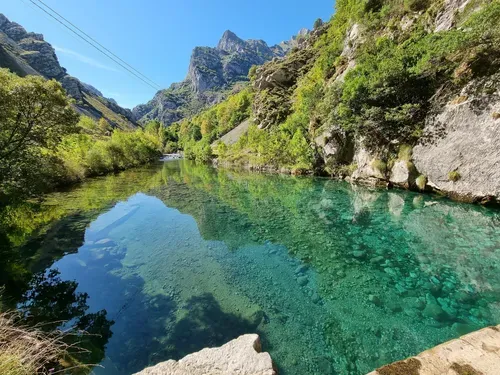 A clear blue body of water sitting down in the mountains at Picos de Europa National Park.