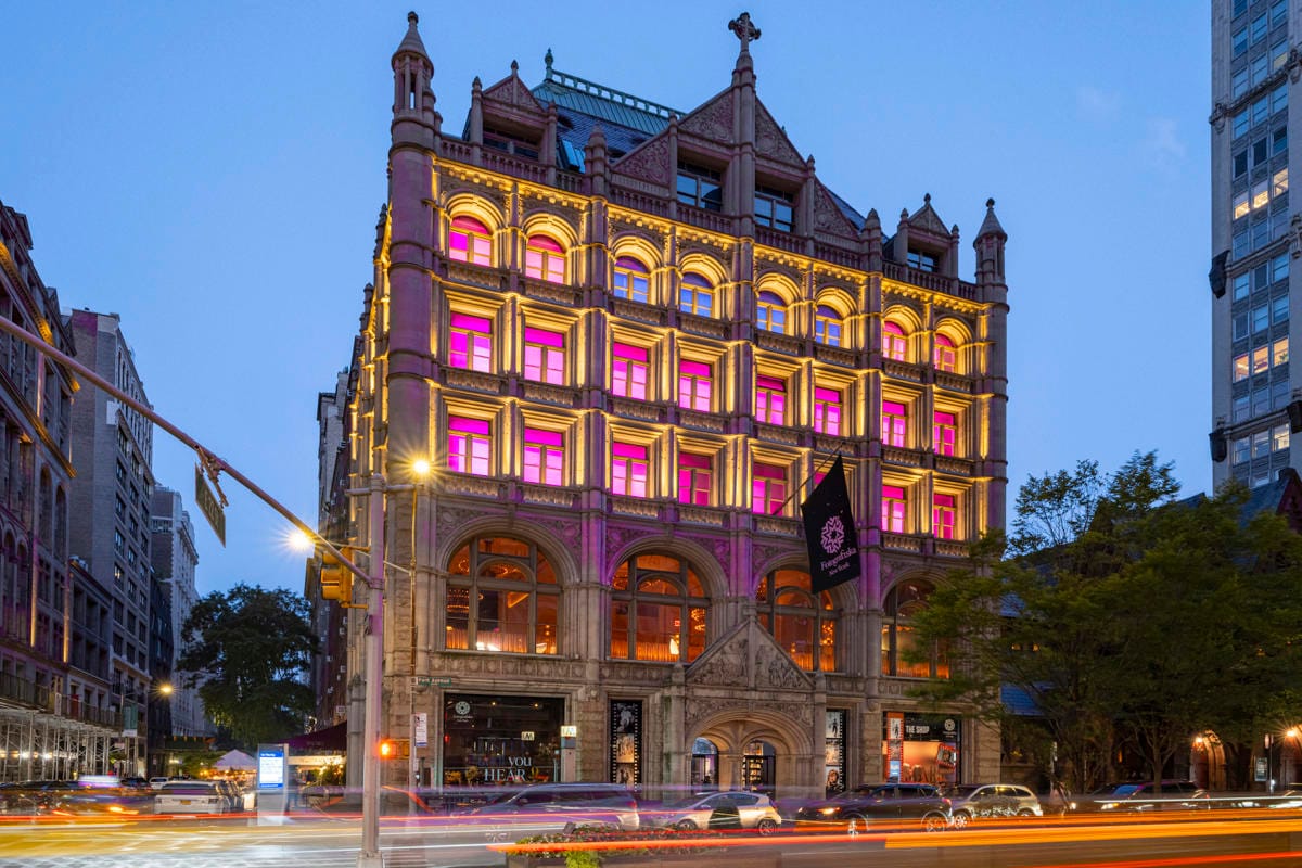 Fotografiska museum lit up at night with pink lights in the windows in Stockholm, Sweden.