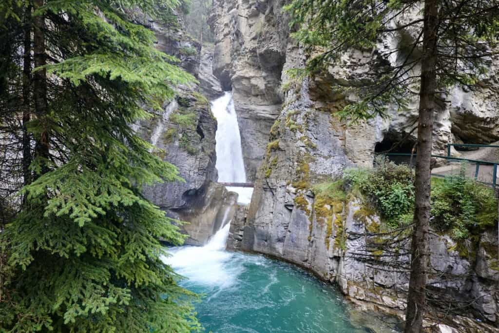 A beautiful water fall coming out of a mountain and dropping into a pool of water at Banff National Park. 