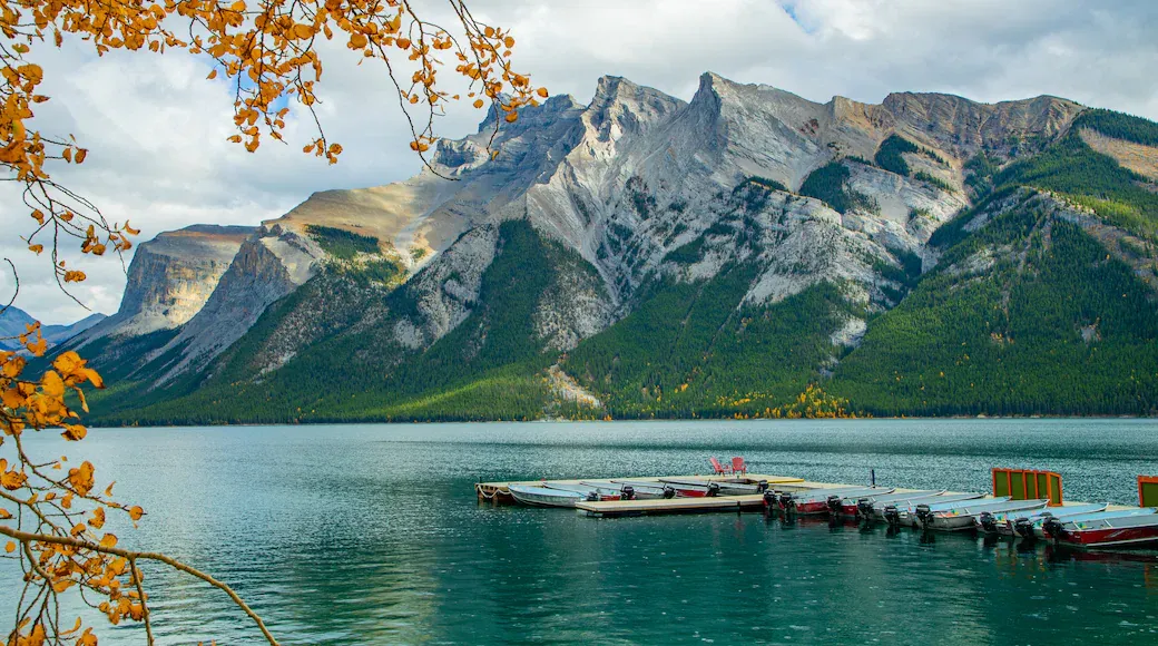 A dock floating in a lake with large mountain peaks covered in snow in the distance. 
