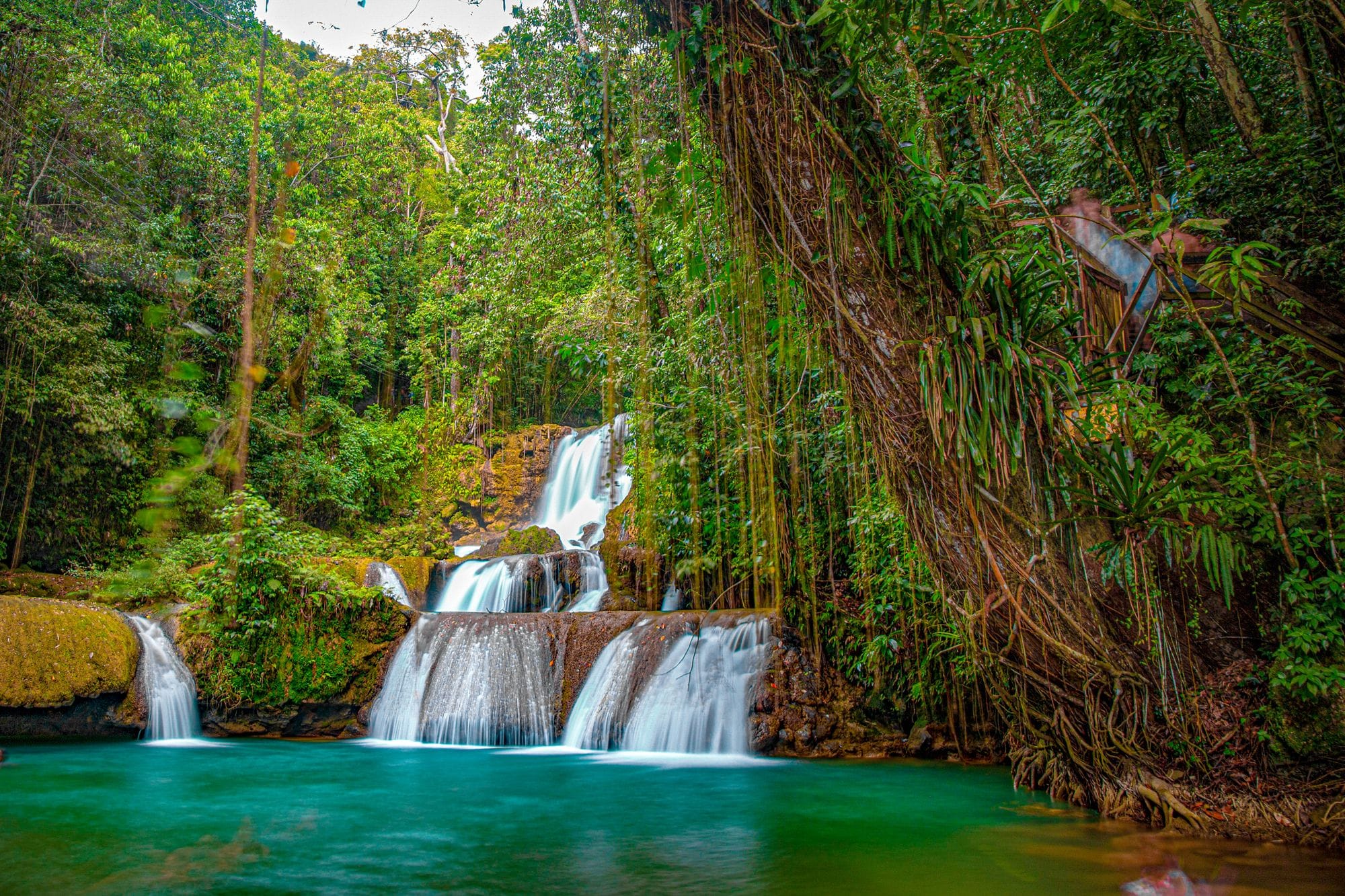 Several small beautiful waterfalls flowing into a pool of water and surrounded by jungle at Mayfield falls in Negril.