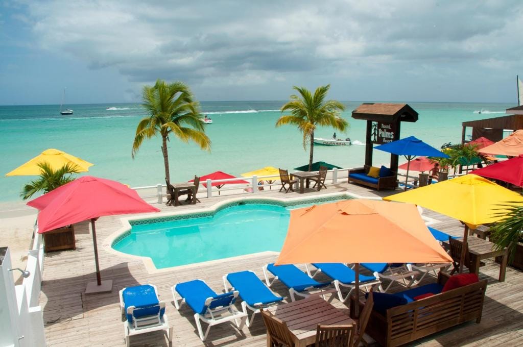 Colorful umbrellas by the pool with ocean views at Negril Palms Hotel On 7 Mile Beach