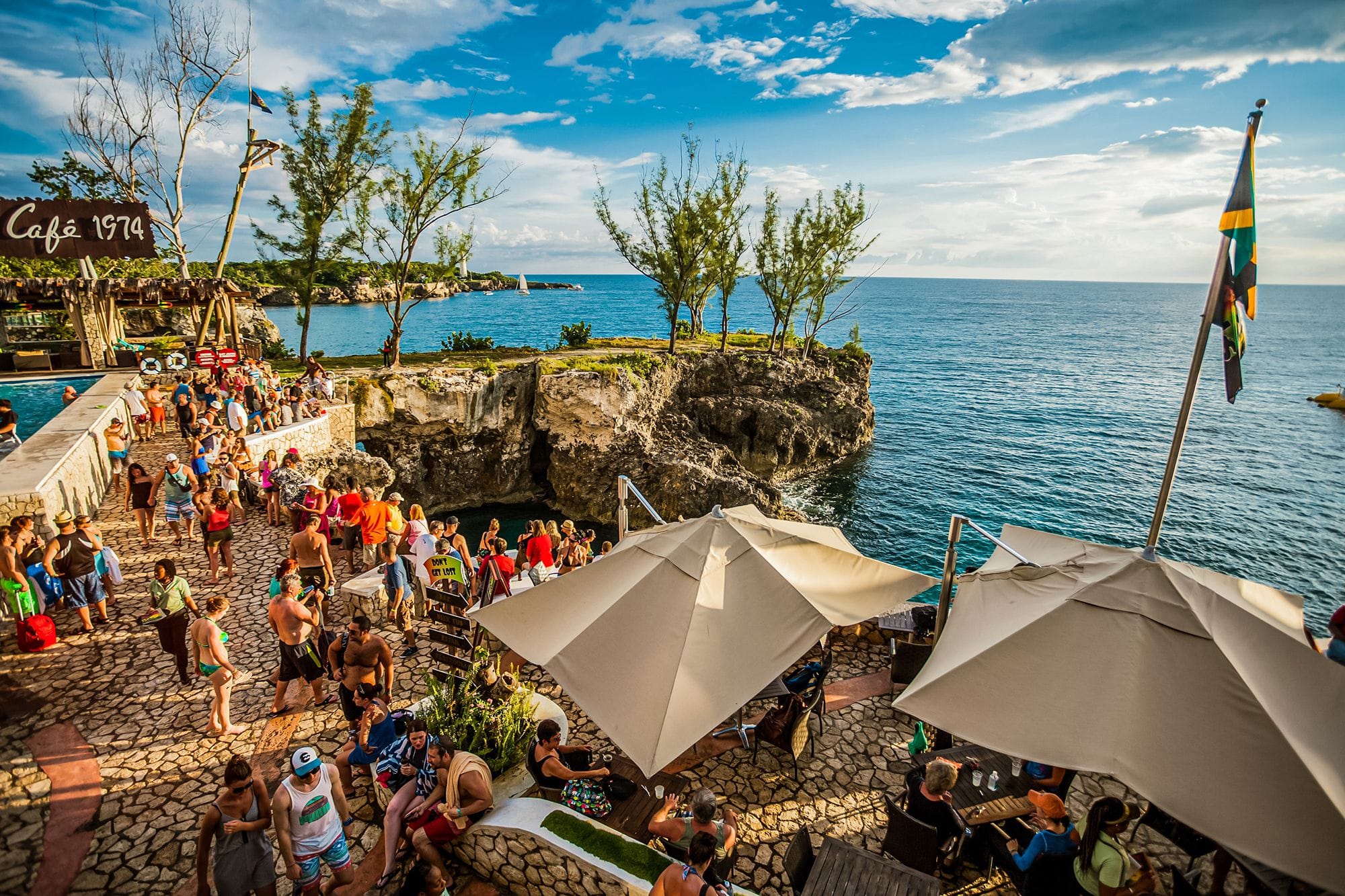  People socializing at Rick's Café on the ocean front listening to music and enjoying the ocean views.