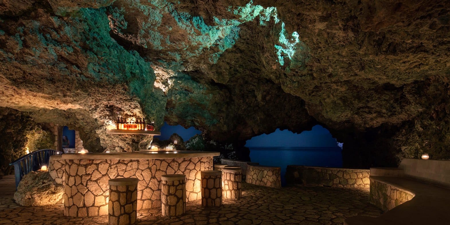 A bar inside the The Caves Resorts in Negril, Jamaica with views of the ocean at night.