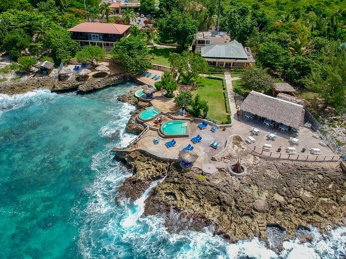 Ariel view of the clear blue waters of the Caribbean crashing onto the rocks at The Westender Inn Negril. 