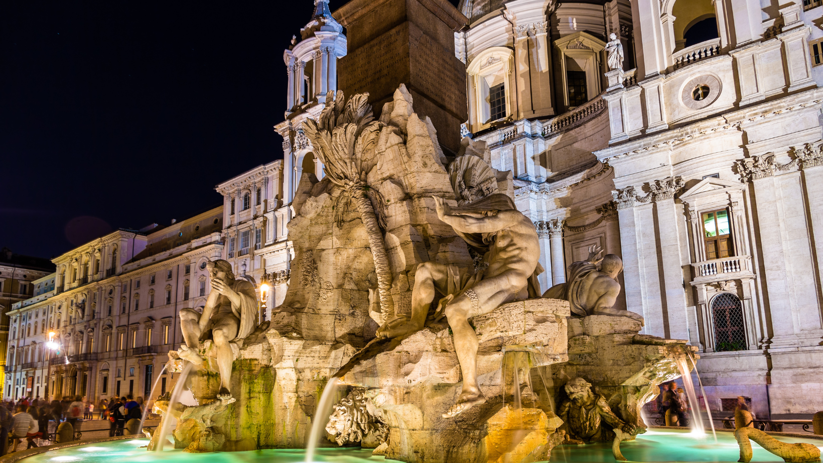 Fontana dei Quattro Fiumi at night lit up with lights in Rome