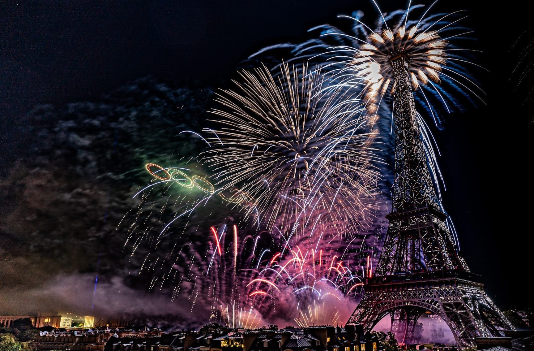 Fireworks being shot off at the Eiffel tower at night.