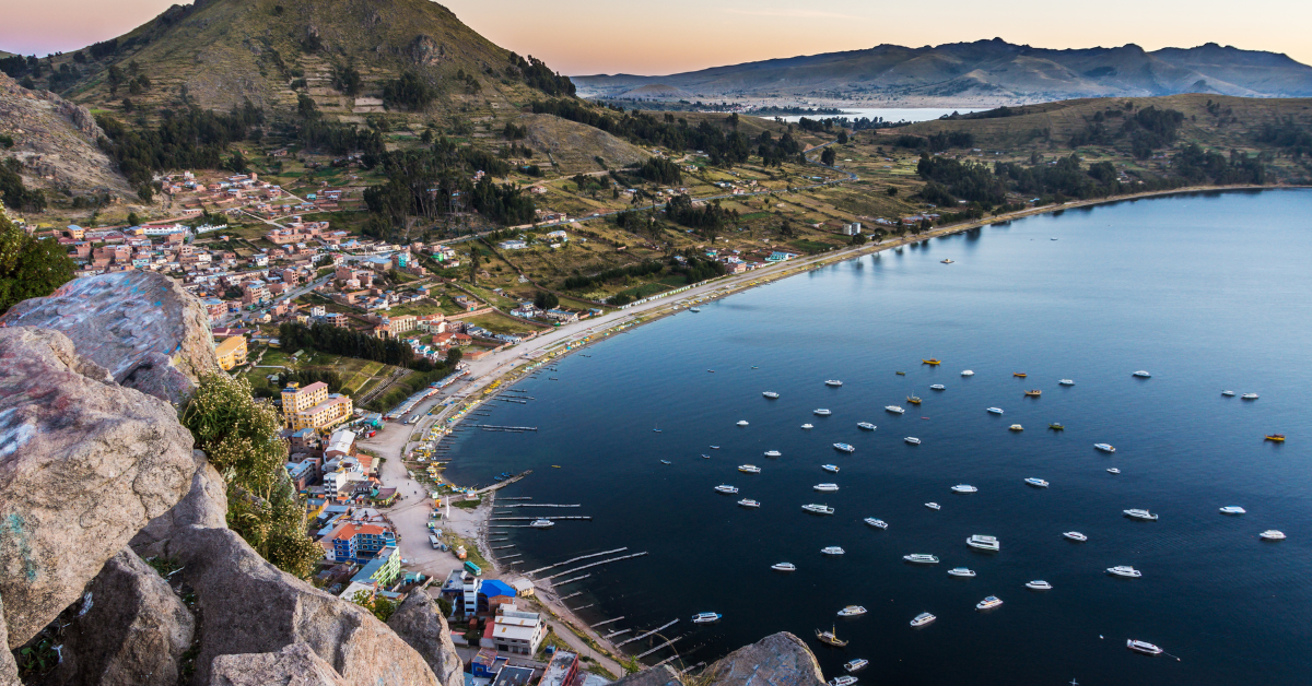 Copacabana, Bolivia- View of Lake Titicaca from the top of a cliff over looking the beach with lots of boats anchored