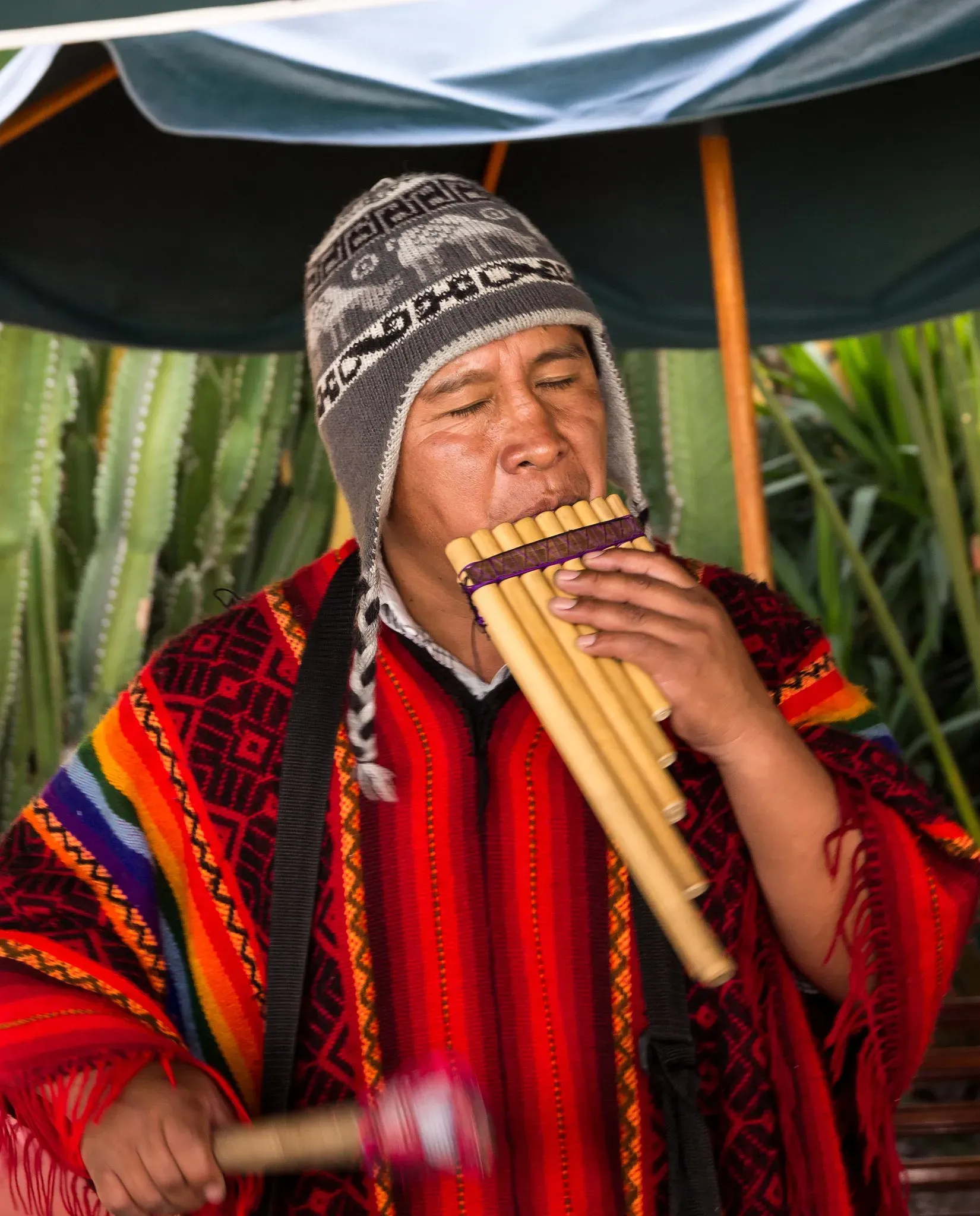 Taquileños Man Playing Instruments and wearing handmade knitted bright red clothing.
