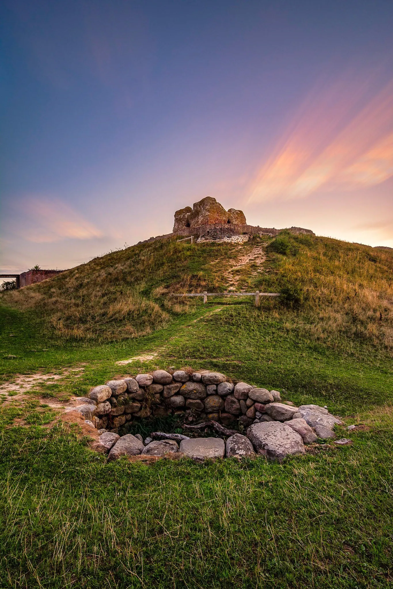 Rocks in a circle in the ground for a campfire at the bottom of a hill below Castle Ruins at Mols Bjerge National Park In Denmark.