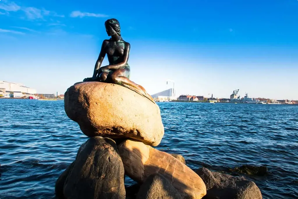 A little mermaid statue sits on a rock by the seaside in Copenhagen, Denmark