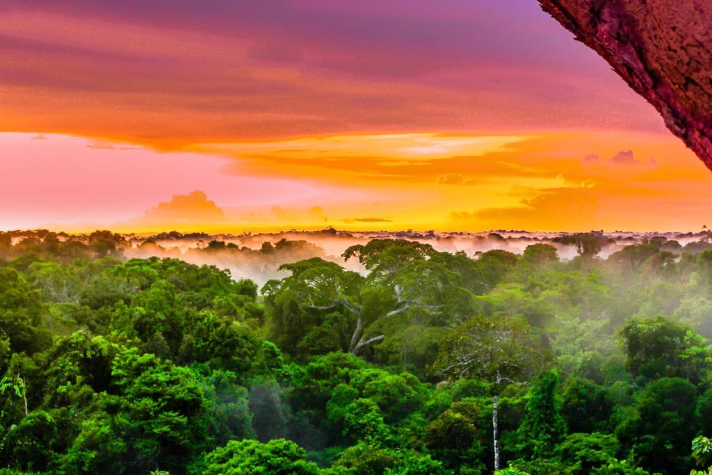 Colombia's Leticia area with a view of the Amazon at sunset with bright orange and red skies over the rain forest canopy. 