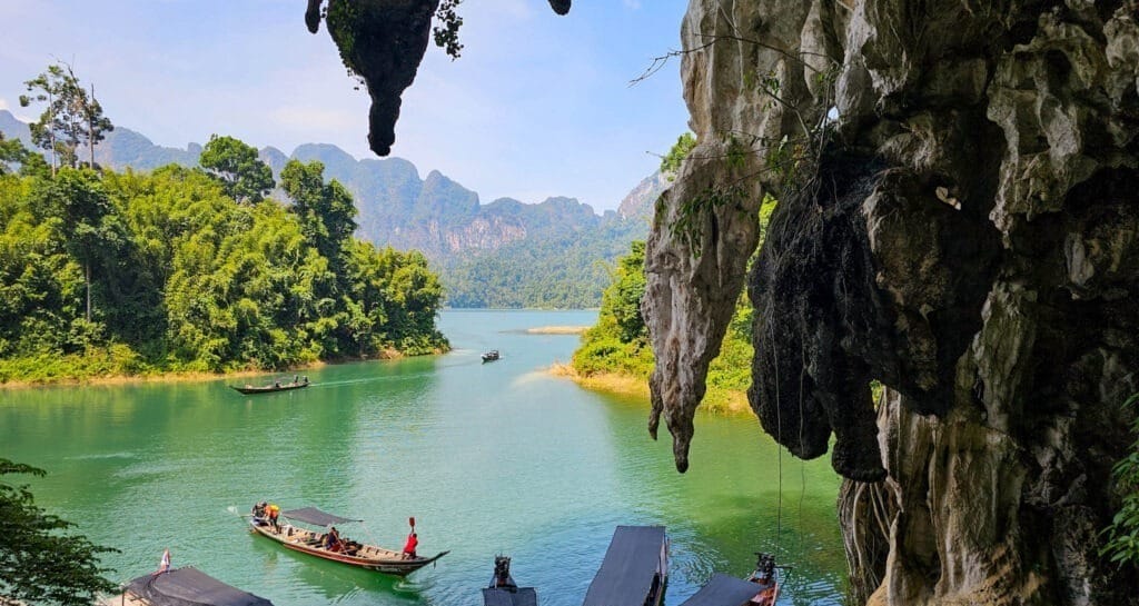 Looking out to the lake from the inside of a cave where the cave mouth has jagged rocked at it's entrance.