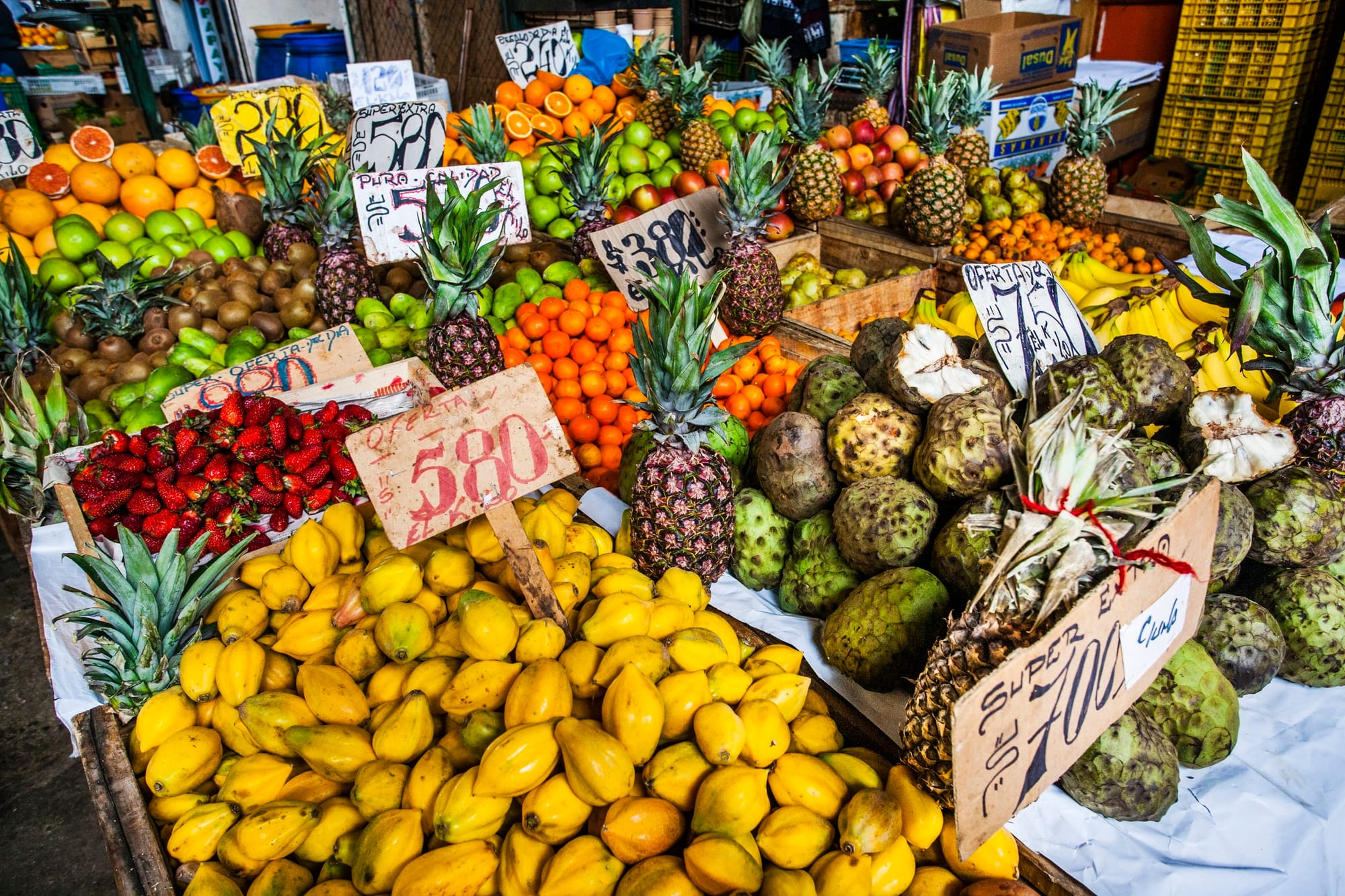 Different colorful fruits sitting out on a table for sale at a market. 