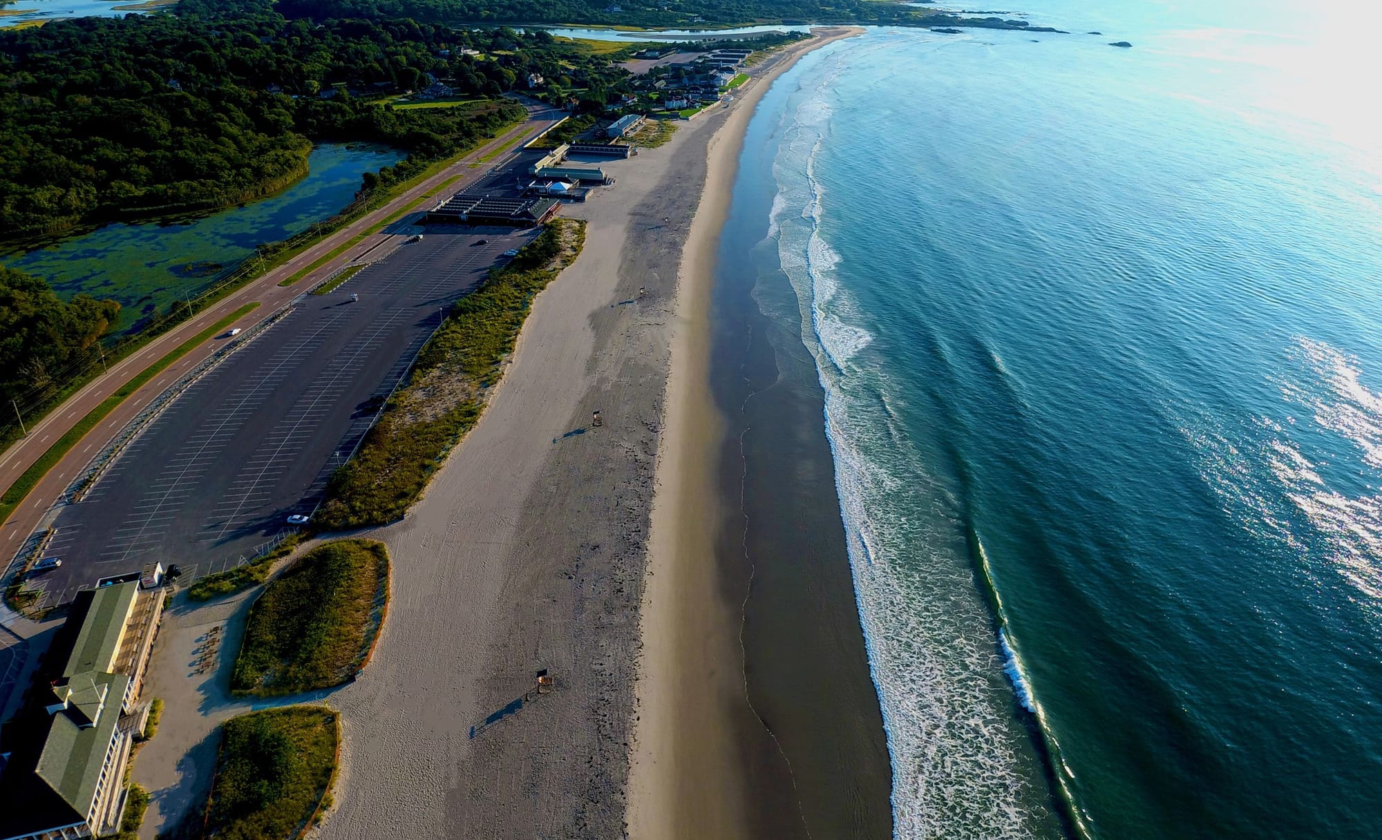 Waves slowly rolling along a clean sandy beach at sun rise. 