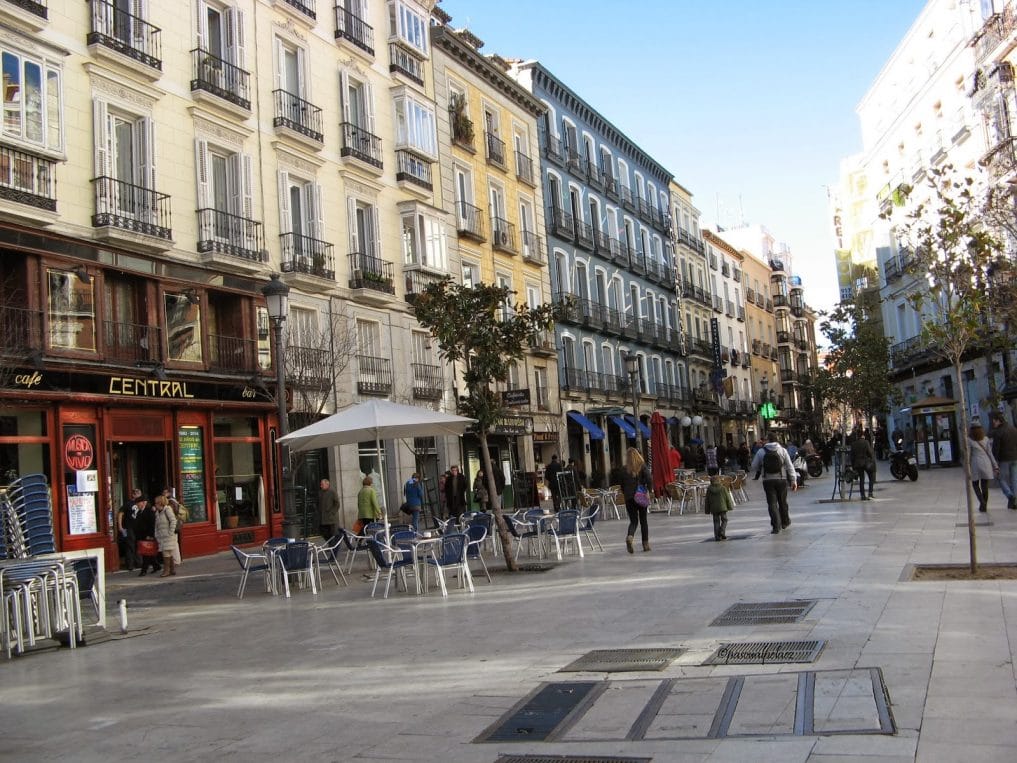 People sitting and walking in Plaza de Santa Ana in Madrid.