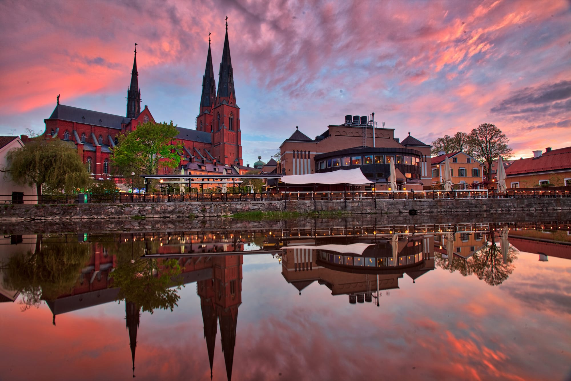 A body of water near a city with a view of a beautiful cathedral in Uppsala.
