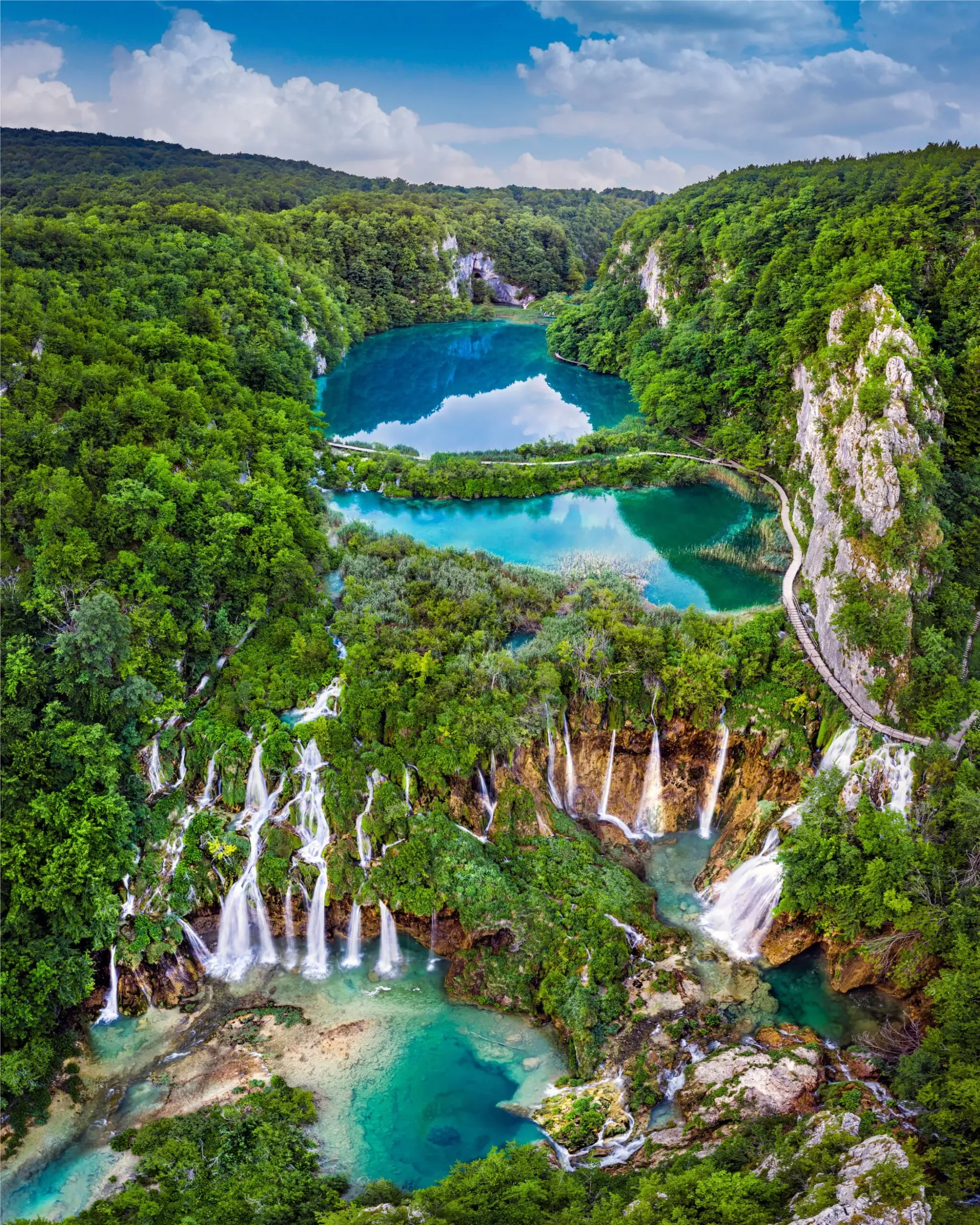 Waterfalls cascade into vivid turquoise pools in Croatia’s enchanting Plitvice Lakes.