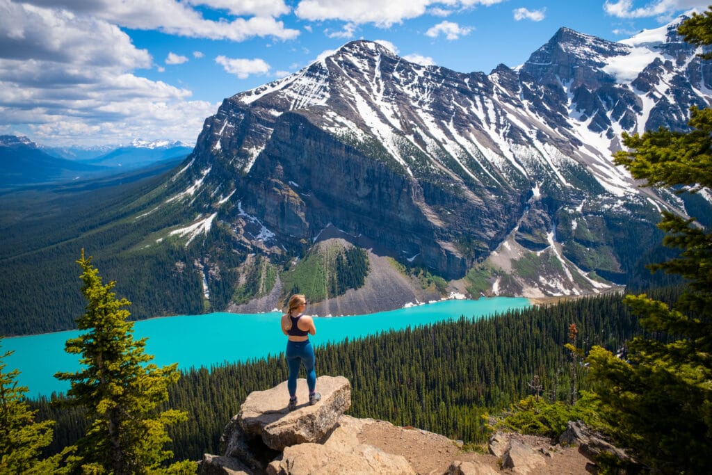 Woman overlooking the turquoise waters of stunning Lake Louise in Banff National Park.
