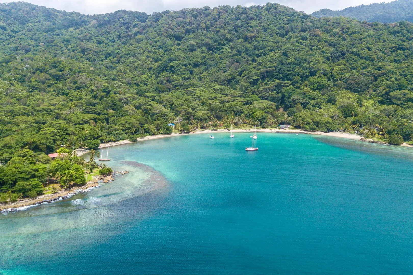 Cabo Tiburón on Colombia’s Pacific coast—a remote, jungle-lined bay with yachts anchored in crystal-clear water.