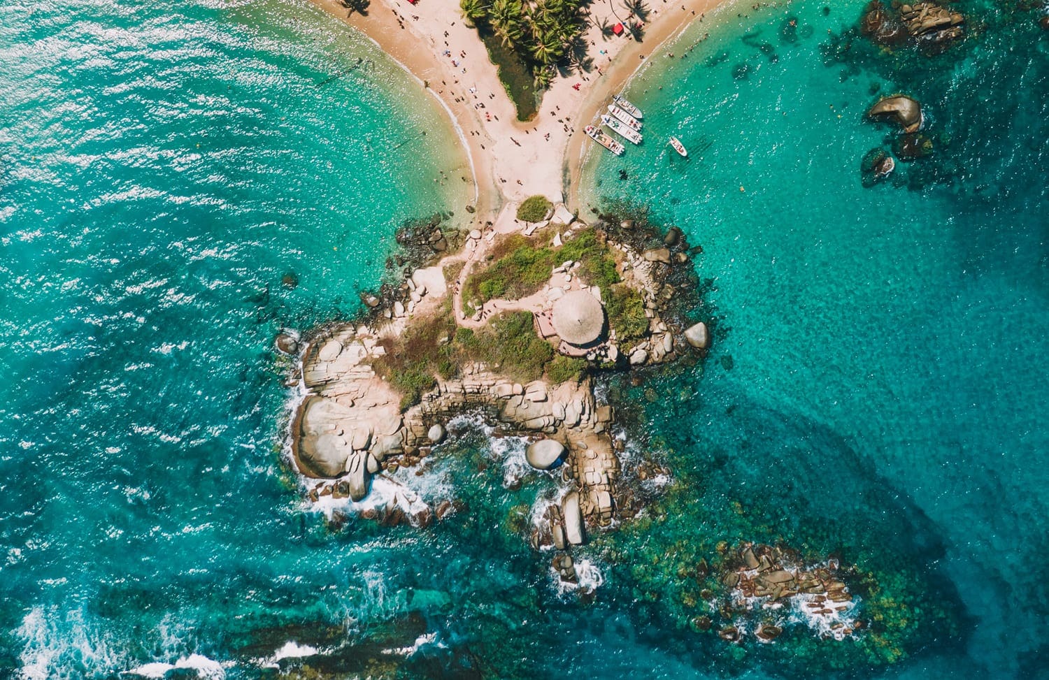 Aerial view of Cabo San Juan in Tayrona National Park—rocky point with iconic hut and twin beaches on both sides.
