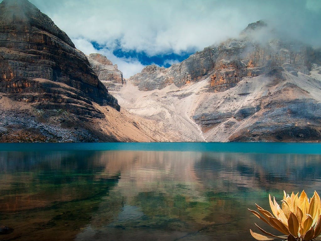 Turquoise glacial lake beneath dramatic mountain peaks in El Cocuy National Park, Colombia.
