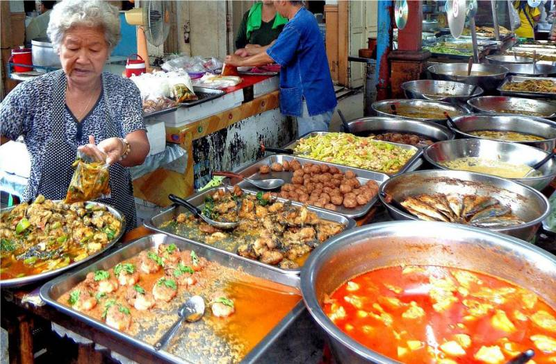 Close-up of freshly caught fish being washed with water in woven baskets at the lively Saphan Pla Fish Market near Mahachai Pier in Thailand.