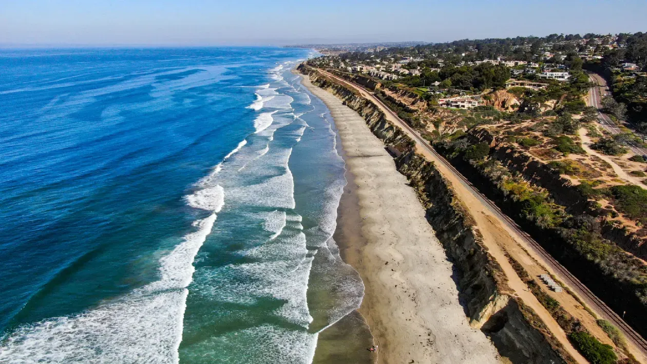 Ariel view of Torry Pines State Beach in San Diego with the Pacific coast highway running the length of the beach.