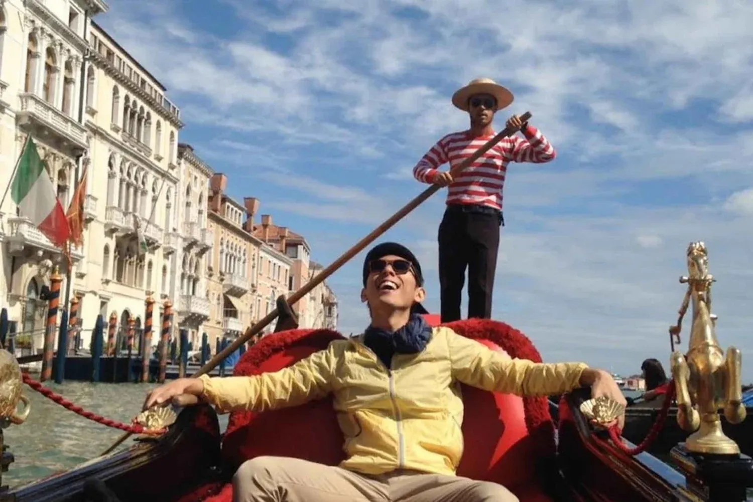 In a boat with a person using a pole to guide the boat on the grand canal in Venice, Italy.