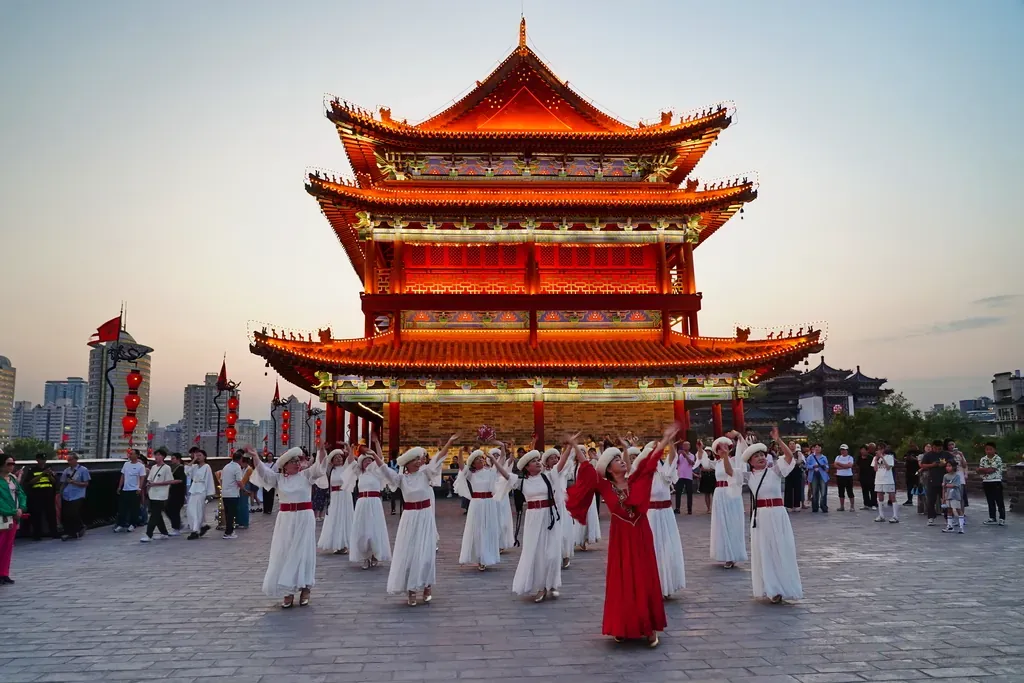 Chinese people dancing in front of a temple in Xi’an, China at sunset.