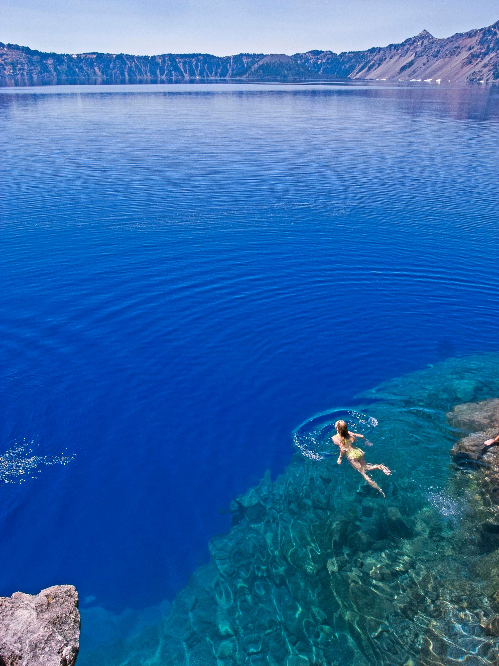 Girl swimming in the clear waters of Crater Lake.