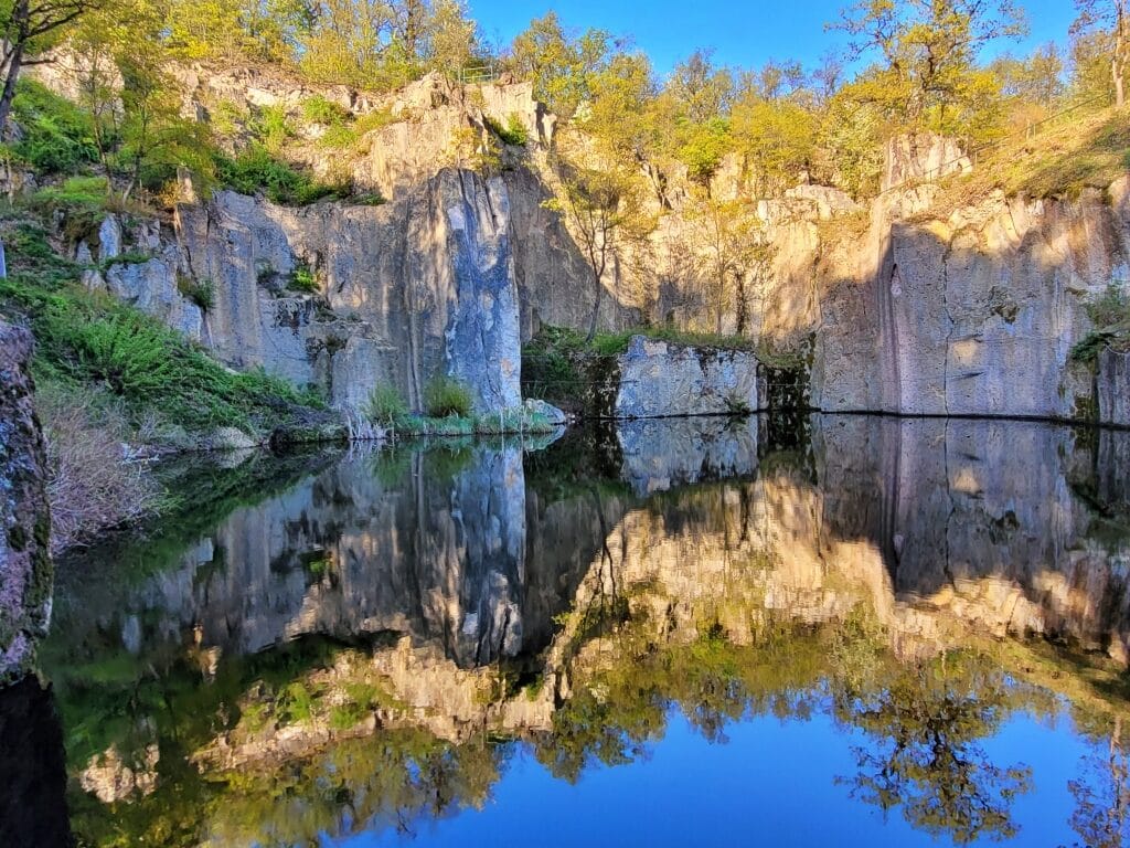 Megyer-hegy Tarn Hungary lake surrounded by rock walls.