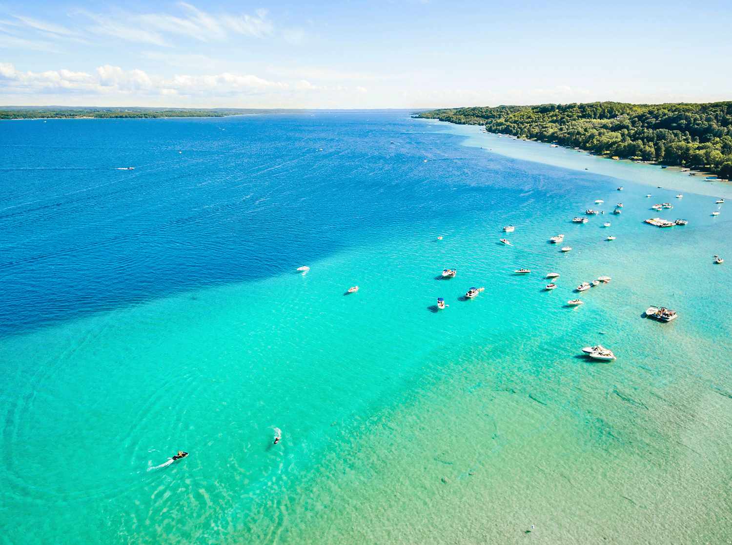 Ariel view of boats parked in clear blue waters of Lake Michigan.