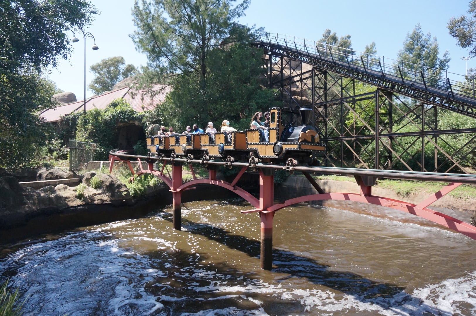 Train taking people overwater inside inside Gold Reef City Amusement park.