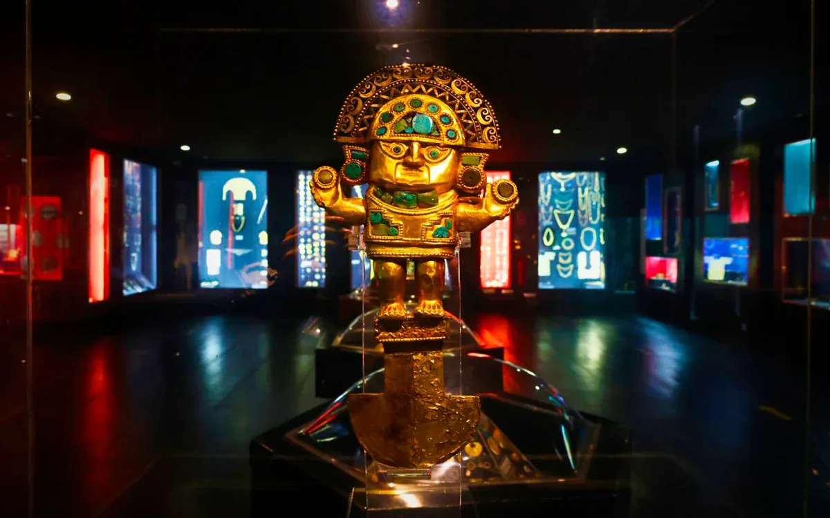 A very old gold statue of a person wearing a decorative hat in the Museo del Oro.