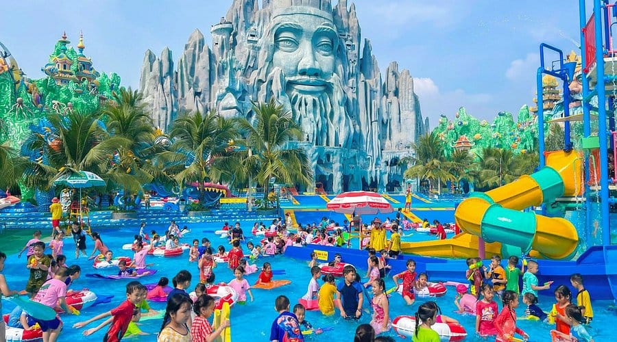 people swimming in a giant waterpark pool at Suoi Tien Cultural Theme Park