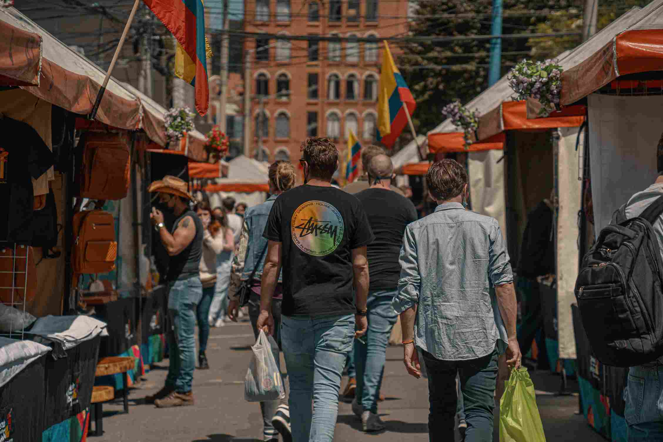 People walking between vendors at Usaquén market in Bogota.